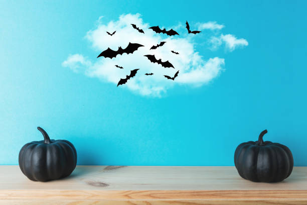 istock Black Halloween pumpkin decor with bats on blue background. Creative Halloween minimal concept. 1168952251