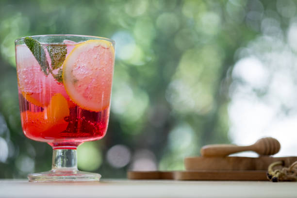 Pink and red fresh colorful exotic alcoholic cocktail with peach, orange and ice in the bar. Colorful pink soft drink with ice