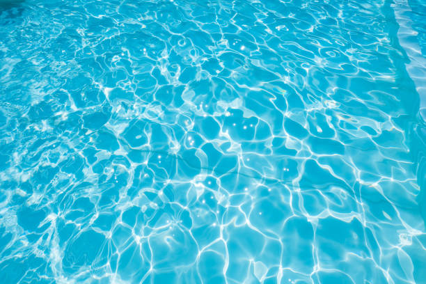 istock Abstract of blue water surface in swimming pool, Ripple wave in pool with sun reflections 1168957019