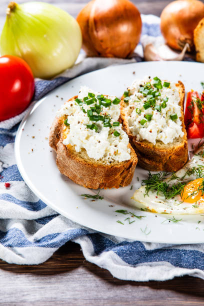 завтрак - тосты, жареное яйцо и овощи - fried egg lettuce vegetable lunch стоковые фото и изображения