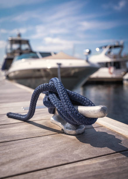 Close up of a nautical knot on a cleat in a marina Blue rope around a cleat, blurred background, space for text, copy space winch cable stock pictures, royalty-free photos & images