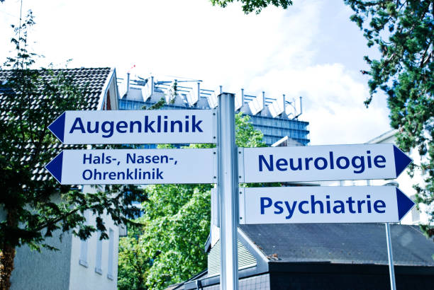 Hospital sign:  Directions to Psychiatry, Neurology, and Eye, Otolaryngology (Nose/throat/Ear) Departments (in German language) stock photo