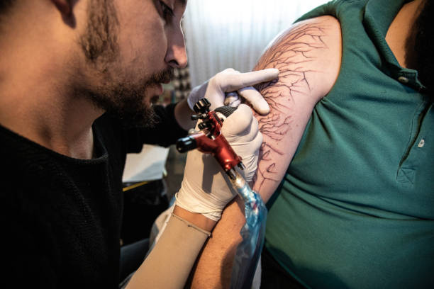 istock Artist making tattoo on customer's hand 1168963705