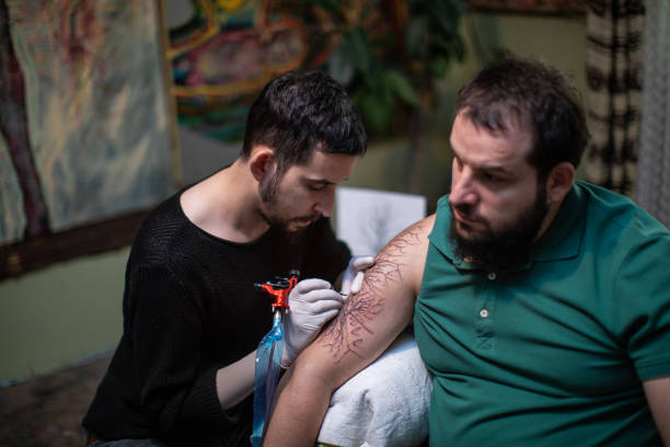 człowiek doświadcza bólu podczas tatuażu - tattoo men human arm shoulder zdjęcia i obrazy z banku zdjęć