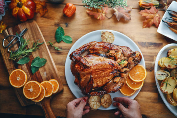 istock Preparing Stuffed Turkey with Potatoes, Carrots, Onions and Orange 1168964926