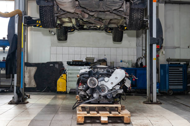 motor da recolocação usado em uma pálete montada o carro levantado no elevador para a instalação após uma avaria e um reparo em uma oficina do veículo como uma garantia para o concessionário. auto indústria de serviços. - pimp my ride - fotografias e filmes do acervo