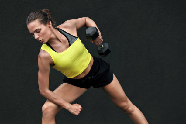istock Sport woman doing back exercise workout with weights at gym 1168967686