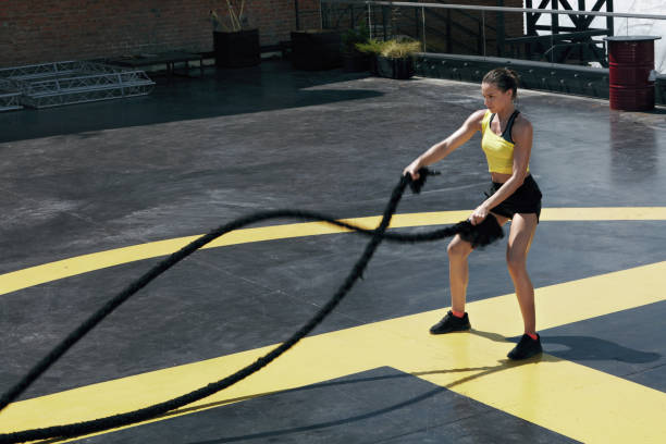 istock Sport woman doing battle ropes exercise workout at gym 1168967757