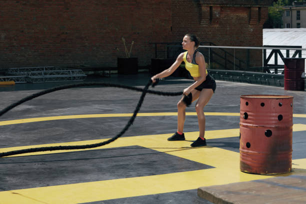istock Sport woman doing battle ropes exercise workout at gym 1168967780