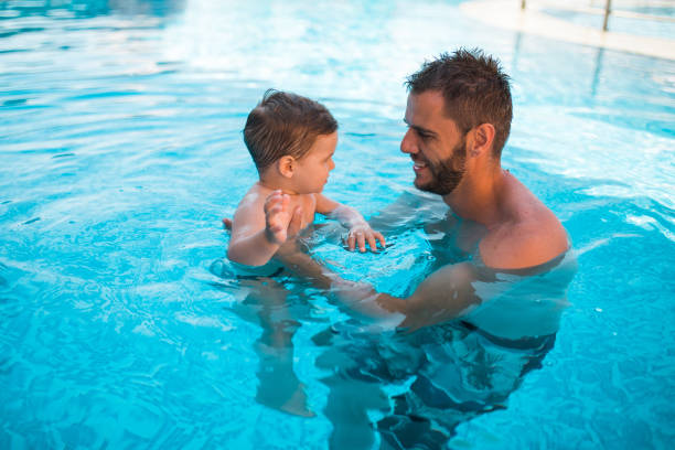 istock Dad learning toddler baby to swim 1168969269
