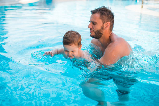 istock Dad learning toddler baby to swim 1168969327