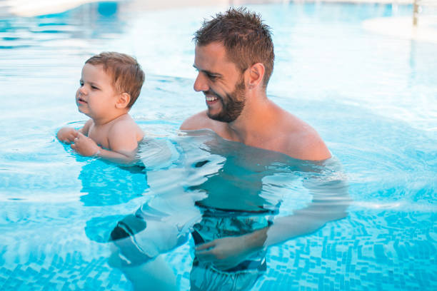 istock Dad learning toddler baby to swim 1168969328
