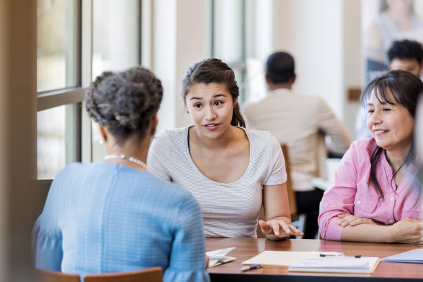 istock Young woman asks loan officer a question during meeting 1168969660