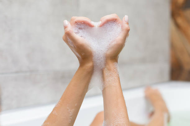 sie macht herz mit händen - relaxation women bathtub bathroom stock-fotos und bilder