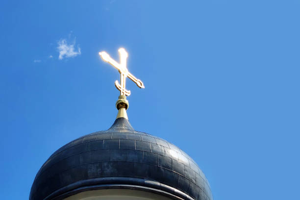 Cross on top of church against blue sky. Minimal concept with copy space