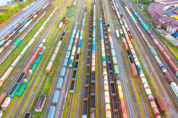 istock Aerial view flight over rail sorting freight station with various wagons, with many rail tracks railroad. Heavy industry landscape. 1168977043