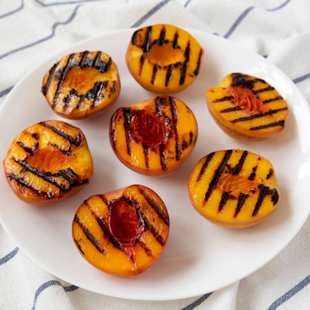 istock Homemade grilled peaches on a white plate, low angle view. Close-up. 1168978528