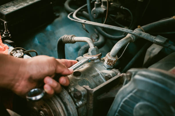 istock Young mechanic working use a wrench and fixing old car 1168979922