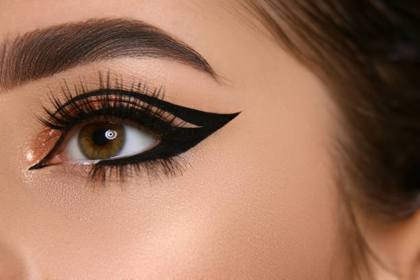 close-up of woman eye with sexy eyeliner and golden shadow stock photo