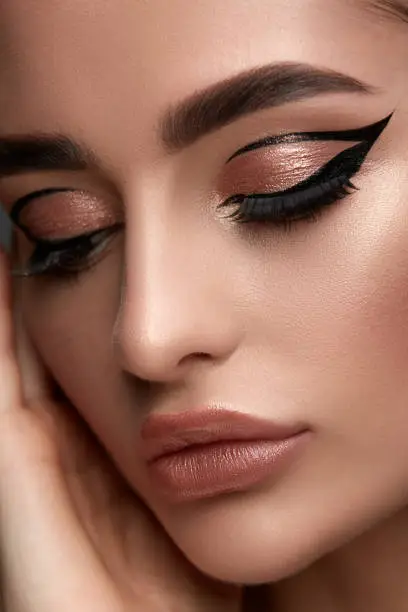 luxury woman make-up with golden shadow and black eyeliner, perfect brows and sexy lips with glamorous mua