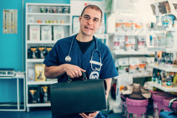 Portrait of a happy veterinarian Smiling veterinarian with stethoscope, holding leather doctor's bag in vet clinic leather medical bag stock pictures, royalty-free photos & images