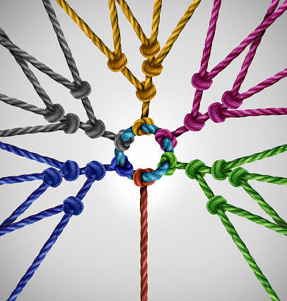 Connected to network groups as an individual connecting to diverse teams coming together to a central point as an abstract communication concept with linked ropes of different colors as a metaphor for social connection.