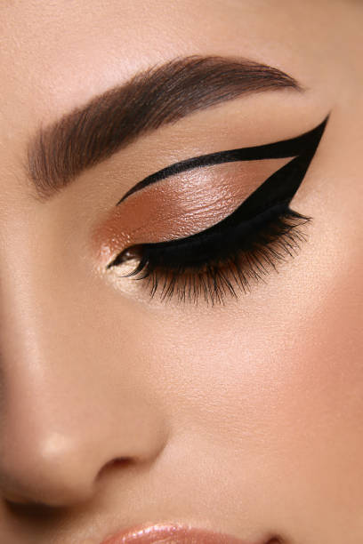 luxury female make-up close-up with eyeliner and golden eye shadow stock photo