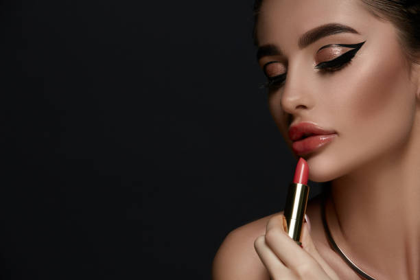 istock glamorous woman with evening make-up holding red lipstick and looking down 1168981433