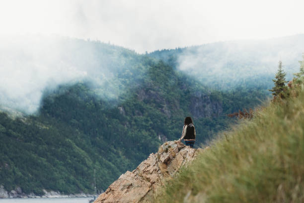 young adult woman on the coastline looking away - saguenay imagens e fotografias de stock