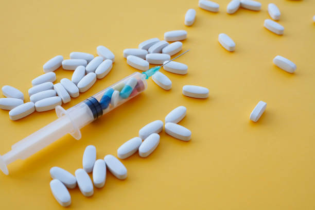 istock Syringe and pills on color background 1168982932
