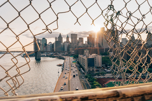 New York skyline at sunset through a hole in the fence