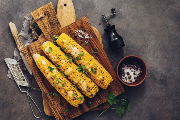 istock Flat lay sweet corn grilled with cheese, cilantro and spices on a rustic cutting board. Vegan or vegetarian dinner or snack. Top view, copy space. 1168986204