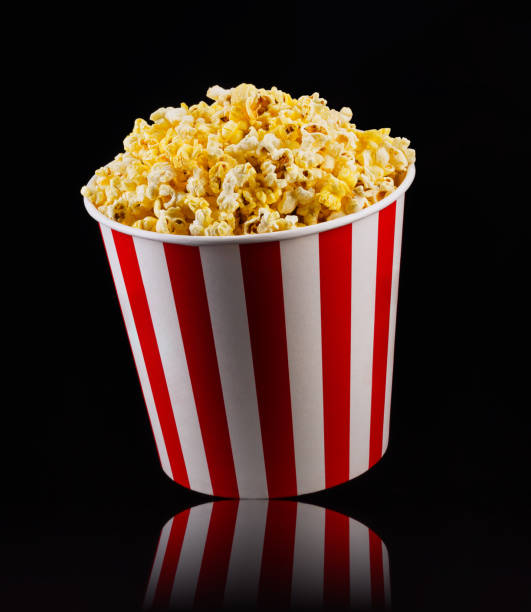istock Paper striped bucket with popcorn isolated on black background 1168987751