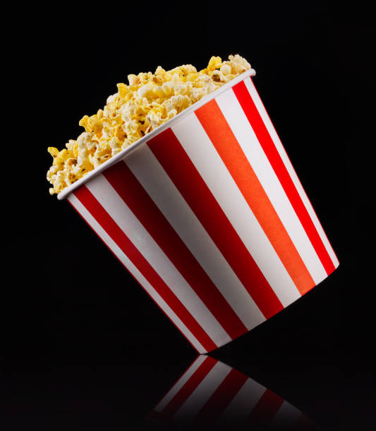 istock Paper striped bucket with popcorn isolated on black background 1168987758