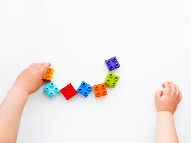 istock Child is playing with colorful constructor blocks. Kid's hands with bricks toy on white background. Educational toy, flat lay, top view. 1168993516