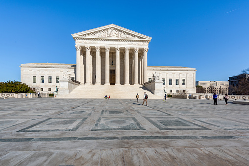 Tourists are walking on square at Supreme Court Building in Washington DC, USA.