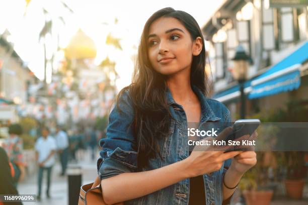 Beautiful And Young Asian Woman Using Smartphone At Kampong Glam In Singapore Stock Photo - Download Image Now