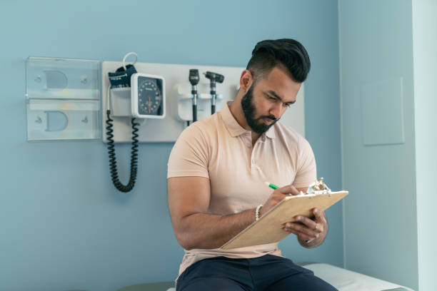 istock Young man filling out paperwork before medical appointment 1168997478