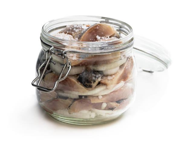 Sliced salted herring in glass jar isolated on white