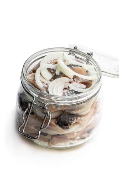 istock Sliced salted herring with onion in glass jar isolated on white 1168998242