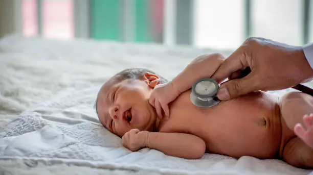 Photo of Soft blur of the doctor hands use stethoscope to check newborn baby health and take care him or cure the disease or disorder