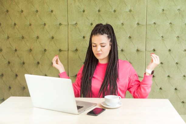 zeit zum entspannen! erfolgreiche junge mädchen freelancer mit schwarzen dreadlocks frisur in rosa bluse haben eine pause, halten hände wie haben meditative emotionalen genuss haben. - turkish ethnicity white black contemporary stock-fotos und bilder