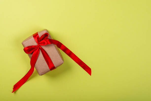 istock Gift box with bow on green neon background. Space for text on the right side of the image 1169005614