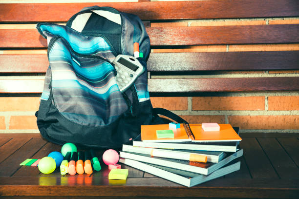 istock Backpack with school supplies on wooden bench 1169006945