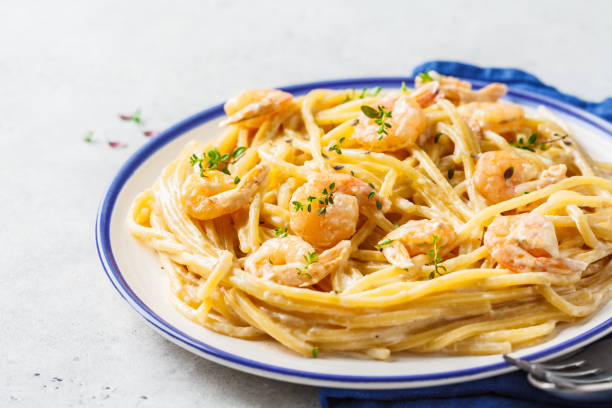 istock Shrimp pasta with cream and herbs in white plate, copy space. 1169009592