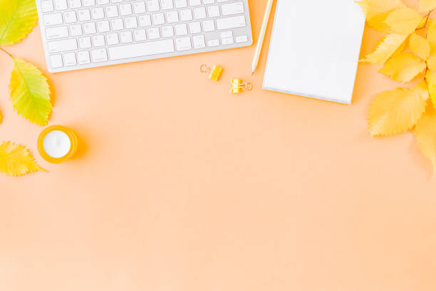istock Flat lay blogger or freelancer workspace with a notebook, keyboard, colorful autumn leaves on a color background 1169013106