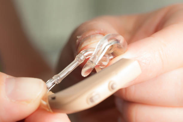 istock senior person holding hearing aid closeup 1169016554