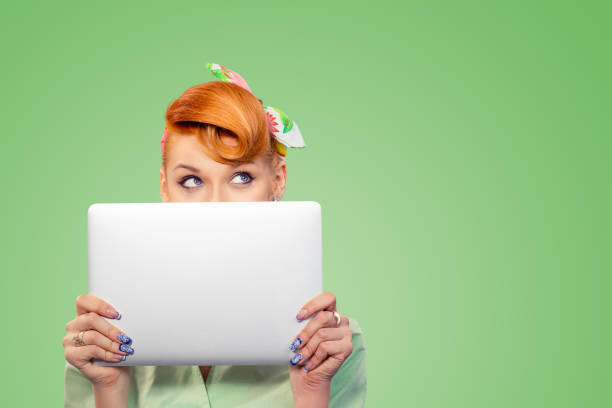 istock pinup girl holding hiding behind computer 1169017315