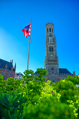 Bruges, Belgium - April 26, 2019 - The Belfry of Bruges, a medieval bell tower, located in the Market Square of Bruges (Brugge), Belguim on a sunny day.
