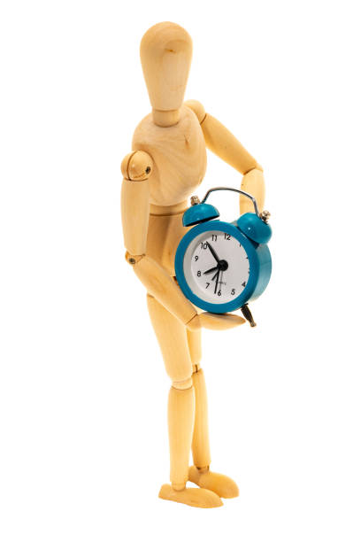 istock Mannequin figure holding an alarm clock 1169022675